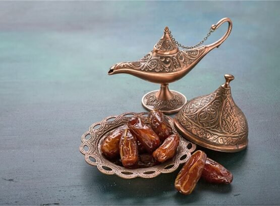 [946208216] bronze plate with dates and aladdin lamp on dark green wooden background. ramadan background. ramadan kareem